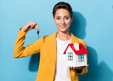 A lady with small toy home with in hand